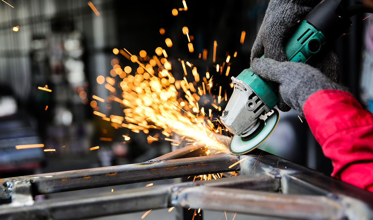 Welder using welding torch in auto repair shop